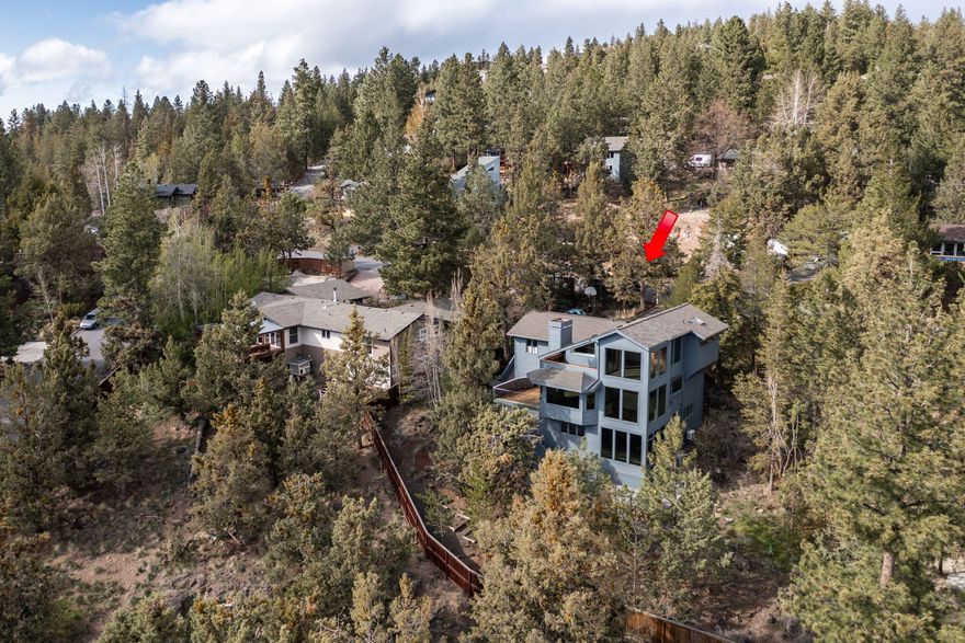 Stunning home with full sweeping city and Cascade Mountain Views sits in the highly coveted area of the West Hills in NW Bend, minutes from downtown. This home has been completely remodeled and offers a spacious floorplan. The entire top floor is dedicated to the primary bedroom with a private deck to watch the sunset over the mountains. There is a large/open kitchen with Slat Cabinetry, new appliances, dining area, a spacious island opening to the great room. Here you will find vaulted ceilings and a stunning concrete wall to floor area with an eco wood burning fireplace. On the lower level, this home offers a big screen in the entertainment room with a mini fridge/bar area, and additional bedrooms. To complete this wonderful home, is an indoor spa room with a dehumidifying system, shower, triple jet Swim-in-Place pool/hot tub, with a UV cleaning system for purification, a separate cold plunge pool, and a steam sauna. On this .26 acre lot there is a shed and fire pit patio.