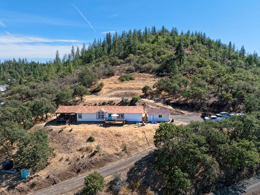 Enjoy panoramic views from this beautifully maintained manufactured home on its own land! Nestled in a peaceful setting, this home offers spacious living with a great floor plan, abundant natural light, and a large deck perfect for relaxing or entertaining. This updated home features 3 bedrooms, 2 bathrooms, spacious kitchen, dining room and so much more. New exterior paint & 2 decks to enjoy the beautiful views. 2 car detached garage gives you room for your toys, or a place to work on projects. Located on just over 5 acres with room to garden, play, or simply soak in the scenery. This home combines comfort, privacy, and stunning vistas.