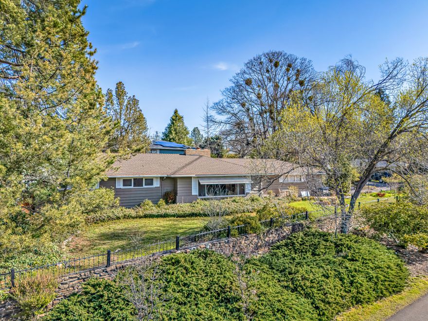 Extremely rare opportunity in Old East Medford on a quiet and private corner lot with beautiful views. Custom built in the mid-1950s by well-known builder Art Dubs, this home has been well cared for with a new high-end roof installed in 2019, a top-tier heating and air system added in 2023, and a new sewer line also replaced in 2019. The home features a great layout with separate living and family rooms, two fireplaces, wood floors, and a recently installed dishwasher. The kitchen includes all appliances. Outside you will find a large RV parking area, a covered carport, two storage areas including a large unit called the ''boat house'' with dirt floors, & a Lincoln log style shed with water & power, a greenhouse, & mature landscaping. The property also includes an oversized 2-car garage. This is a solid home with great bones & potential for updating to make it truly shine. Ideal for a first-time buyer or investor.