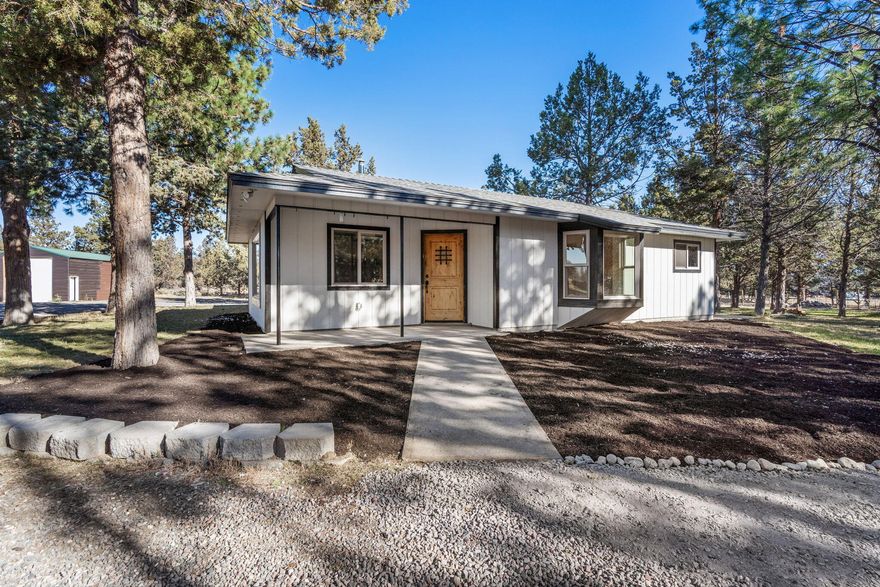 Don't miss this opportunity to own a cozy cottage on a gated 5.12 acres in the heart of Tumalo horse country. Located next to Healing Reins with MUA zoning the possibilities are endless. Recently updated interior boasts A/C, hardwood floors in the main living areas, carpet in the bedrooms, cozy stone surround pellet burning stove, & massive wood wrapped windows for an abundance of natural light throughout. Kitchen ftrs granite counters, copper farm sink, full height tiled backsplash, propane range, massive island w/brkfst bar seating & all stainless steel appliances. Two large bedrooms share a well appointed full bath w/large mudset tiled shower. Laundry area w/built-ins. Huge detached 2+ car garage w/additional storage + shop space, hay barn, RV Parking + storage, covered patios front/back, fenced for horses, irrigation pond, NO HOA or CCRS! Bunkhouse on site ready to be finished your way!!!