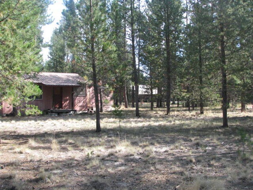 Create your own peaceful retreat on this beautiful 2.16 acre parcel.  Close to city center with easy access to river, lakes and mountains. Enter the gate and drive down the gravel driveway where a 1440 square foot shop awaits. Concrete floor, fully insulated, 12 foot door and man door.  200 amp service providing 110 & 220, LED overhead lighting,  22 foot height inside. Off to the side a small cabin awaits your creative finish. Cabin is bare to studs, not a livable space.  Could be renovated as a guest cabin, ADU, or removed to build your dream home. This property provides plenty of space to store your toys, RV, boat, snowmobiles or.....Septic was recently pumped and inspected,  newer well provides plenty of water. Paved roads to access property. Come see how quiet and serene living here can be !! Bend is about 30 minutes away, Sunriver about 12 miles. Owner is a licensed broker in the state of Oregon.