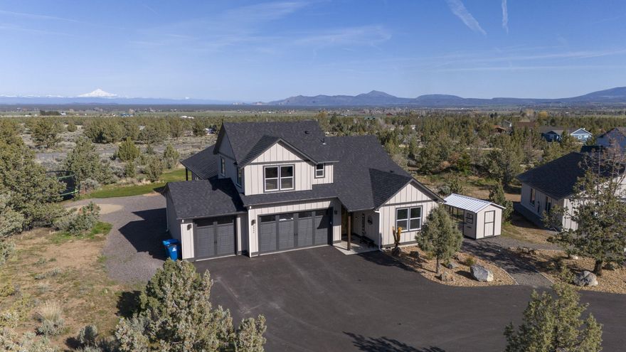 Beautiful 2022 home with 3-car garage in Powell Butte on 4.84 acres on a paved dead-end road. Featuring open concept living/dining/kitchen with vaulted ceilings, LVP floors, oversized windows, and amazing views. Main room separation, utility room w/sink and office. Jr. suite/bonus room above garage! Large kitchen features wood cabinets, island/eating bar, walk-in pantry, SS appliances with quartz countertops throughout. Covered front porch and a 15'x40' covered back patio w/ exposed wood beams makes for the perfect spot to watch the sunset & enjoy your backyard views! Main room features a large walk in closet, tile shower, enclosed toilet, double sinks, and door to patio. Fully fenced perimeter, automatic entry gate, asphalt drive, landscaped, hot tub, 30x50 shop with two additional 12X50 covered/sided lean-to, 200 amp electrical service to shop with 2-14x12 automatic garage doors. The detached 30x32 rec room/garage features vaulted ceilings, heated with a pellet stove and insulated!