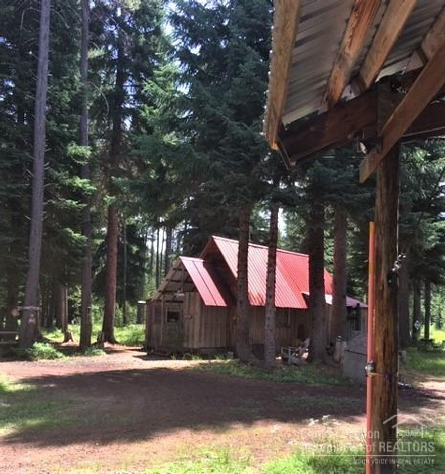 Tucked away in the trees with Creek bordering the entrance. Bridge with culvert gives access to the land. Prime location in Crescent Lake located off Royce Mountain Way. This property is zoned F with huge old growth trees throughout the 11.02 acre parcel. Beautiful & scenic. Original cabin on site with an older 1990 manufactured home protected by large snow roof. With a lot of TLC this 3 bedroom/ 2 full bath could be ideal. All rooms are unusually large and open. Wander down mowed paths to the fort built at the back of the property. A sand filtered septic system is in place. Private well.