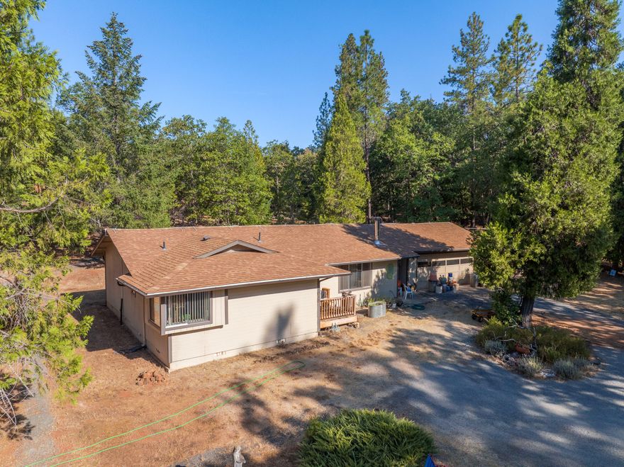 Discover this private country home with a large shop on 2.54 acres of usable land just minutes from town. This single-level residence features 3 bedrooms, 2 bathrooms, and a 2-car garage, plus an impressive 1,368 sq ft shop with its own electrical panel, finished office with A/C, high ceilings, and a 15-ft wide door. Inside, the oversized primary suite offers bay windows with abundant natural light. The kitchen, dining, and living areas flow in a spacious great room design anchored by a free-standing wood-burning fireplace. Recent upgrades include new flooring. Outside, the property is fully fenced with fire-safe landscaping, a fenced garden, a 2,500-gallon water holding tank, a seasonal 27,000-gallon pond, and a second well. Enjoy a rare balance of country living with modern convenience—ready for your next chapter.  Property is to be sold ''Where is/As is''