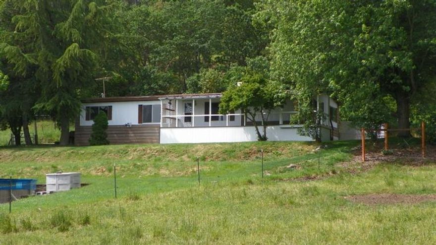 Here is your opportunity to get into 5 plus acres of irrigated land that is fenced and ready for you to put your livestock or plant your huge garden. The TID runs at the top of the property so super easy to irrigate. The home has been freshly painted on the inside along with new carpets and linoleum. The two car garage is large and a third bay that is a shop. Small barn area as well. Extremely Private!!