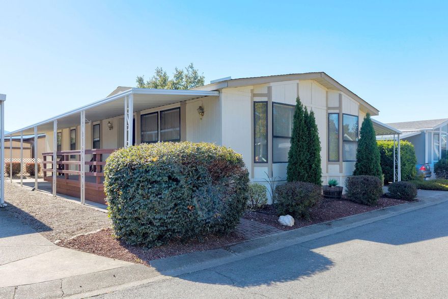 This spacious 2 bedroom, 2 bath, 1512 square foot home is located in a desirable 55+ community. This well-maintained double wide offers an inviting covered front deck, a covered carport, and a utility shed for extra storage. Inside, you will find an open and comfortable layout with multiple walk-in closets, a primary suite featuring a double vanity, and plenty of natural light throughout. Built in 1986, this home combines comfort and convenience in a peaceful, well-kept neighborhood- perfect for relaxed, low-maintenance living.