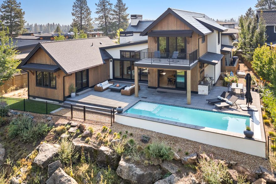 This spectacular mountain-modern home in fabulous Discovery West is located at the end of the only cul-de-sac in the neighborhood, offering wonderful privacy as it backs up to a natural park that will never be developed. This beautiful 4-bedroom residence features 3266 sqft of beautifully designed living space, which perfectly balances lifestyle comfort with entertaining. The open floor plan boasts soaring ceilings, along with a chef's kitchen loaded with top-tier appliances, stylish Dekton counter-tops, custom cabinetry, and a spacious walk-in pantry. The gorgeous primary bedroom suite is located on the main floor along with an additional ensuite bedroom and large office. 2 more bedrooms upstairs along with a bonus room and balcony overlooking the heated pool, outdoor kitchen and natural park below. Talk about energy efficiency...this home has a Tesla roof and 2 Tesla Powerwalls in the garage! This is truly a one-of-kind residence in Discovery West!