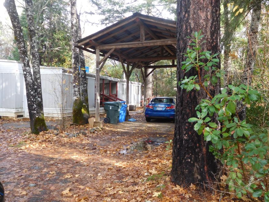 In town, level city lot, with an older s/w mh with expansion, on it. Very tall, free standing RV parking or use as a carport. Treed lot, needs mtc. Close to all downtown conveniences and Elementary School. Located on paved, dead end street. Value is considered to be in the land only.