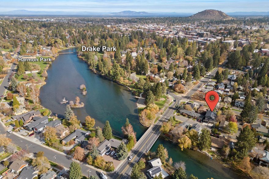 Downtown Bend home with views of the Deschutes River & Drake Park. Enjoy watching deer, jays & ospreys from your deck and living areas. There is a 1 bedroom apartment with a separate entrance that can be used for guests, full-time tenant or Type I STR (short term rental as owner occupied). Main home has been updated to include new upstairs bath, Bosch stainless steel appliances, Sub Zero refrigerator, custom floating staircase, wood floors throughout, composite deck, & closet built-ins. Primary suite on the main level has vaulted ceilings, walk-in closet, dual sinks, tile shower & soaking tub. 500 SF loft is perfect for an office or work studio. Apartment with full bath, kitchen with Fisher Paykel appliances and a private back deck can be locked off from the main home. Oversized 3 car garage w/epoxy floor & workbench/closet. New roof, garage doors and exterior paint in 2020. AC & solar hot water. Lot is RM zoned. Hot tub & easy maintenance yard. Room for oversized van in the driveway.