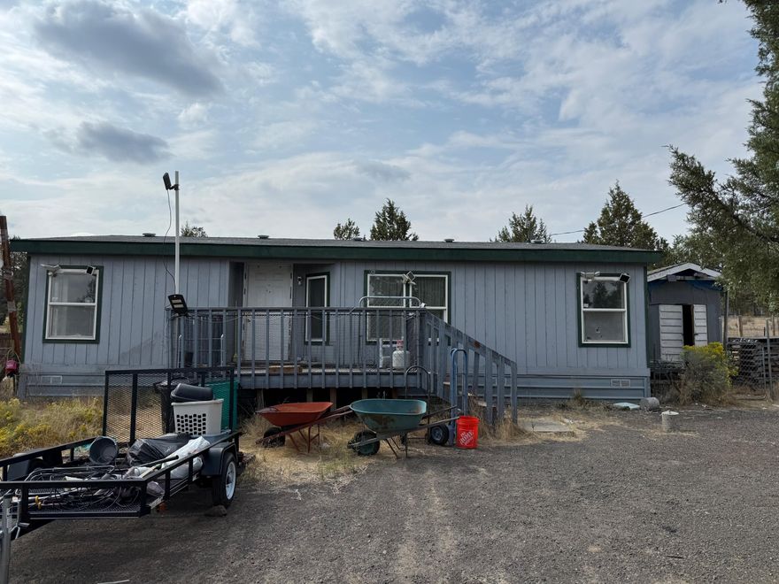 This 1995 manufactured home on Crooked River Ranch features 3 bedrooms, 2 bathrooms, and sits on 1.06 acres. Set toward the back of the property, the home offers added privacy. Two storage sheds provide additional space for tools or equipment. The property requires extensive repairs and is being sold strictly ''AS IS''. Seller will perform no cleanup. Please, no drive-bys.