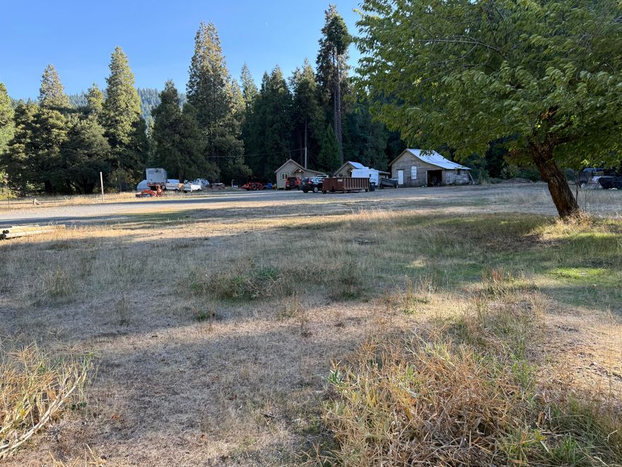 Got History??  Beautiful property with 2 cabins & one other building that was there when first developed many years ago. One Cabin,occupied, is very livable. The other needs to be finished renovated. There is a beautiful year round creek, that divides the property, that supplies irrigation rights for 18 acres, to  a large meadow near cabins. Commercial septic system (4,000 gal) and a unreal supply of water from a spring that is located on the property, for domestic use .
A large area below cabins, is  where a great garden spot could be located too. Serene setting, improvements way back off the highway, apx 11 miles to city of Cave Jct.  So much potential to develop a lot more uses. Truly one of a kind!