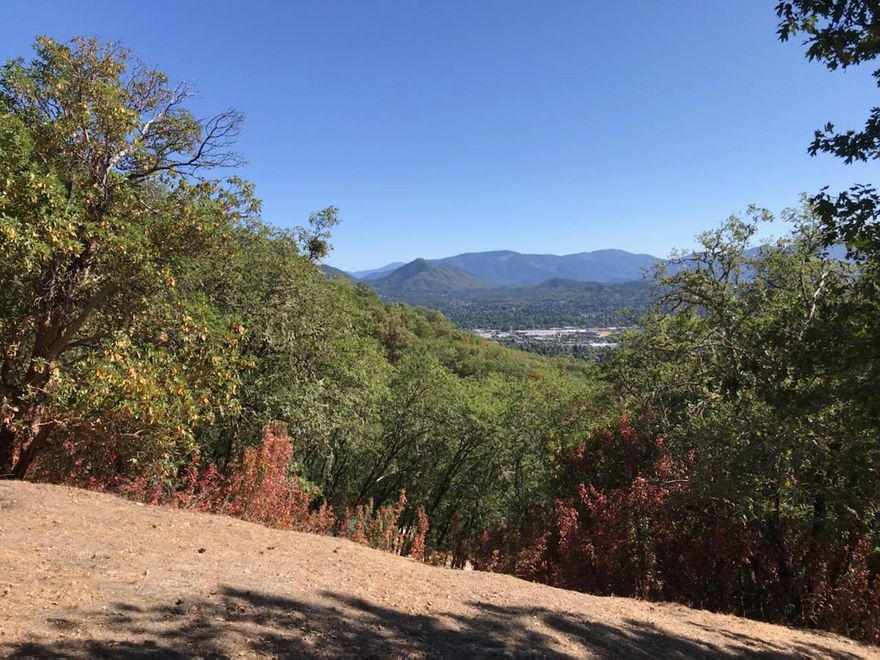 Gorgeous western views from this private 3+ acre residential zoned parcel heavily treed with a mix of madrone, oak and Douglas Fir in District 7 schools. Water, sewer & power at the paved city street. Roughed in driveway. 300+ acres of BLM along eastern border.