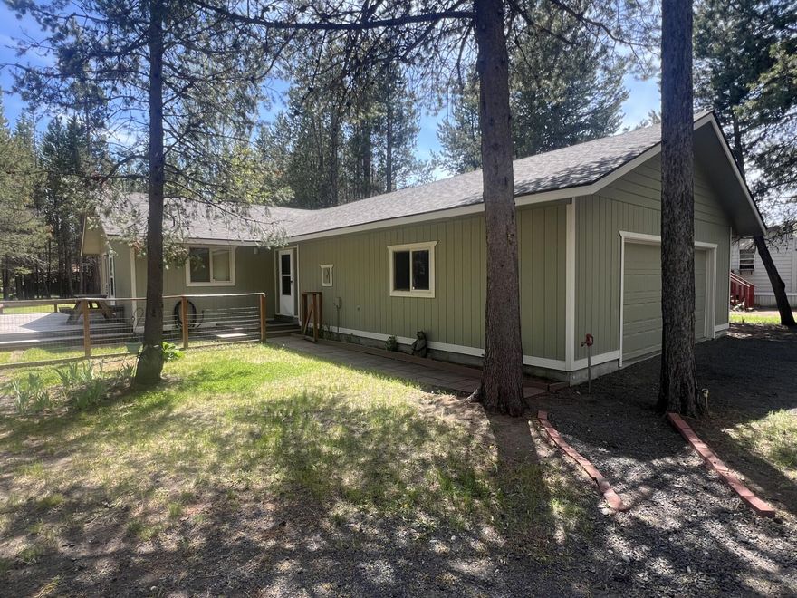 Charming, move-in ready home just steps from the Deschutes River and a community boat launch! Tucked back on a wooded lot, this peaceful retreat offers a private backyard and an expansive 24x10 deck—perfect for relaxing or entertaining. Inside, the open great room features vaulted ceilings and natural light, creating a bright, airy feel. With 3 bedrooms, 2 baths, a spacious primary suite, and a dedicated utility room, this home offers both comfort and function. The oversized garage includes workshop space and a breezeway entry from the front porch. Enjoy community water/sewer, paved roads, and easy year-round access. With neutral finishes throughout, this home is the perfect canvas for your personal style. A rare gem in a tranquil riverfront community!