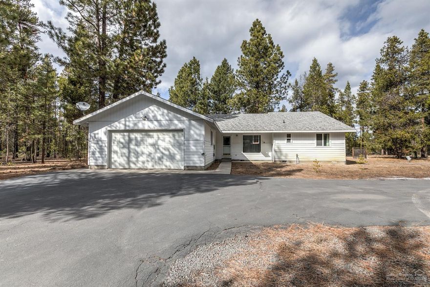 Situated on the border of BLM in the Deschutes National Forest, this is the perfect spot for a private oasis just minutes from town. Well cared for single level home has had just one owner & is ready for your personal touch. Huge living room space for comfortable entertaining w/adjoining kitchen & sunroom. Wood burning fireplace to keep you cozy & warm during the winter, mature pines outside provide summer shade for efficient cooling. Bedrooms are spacious w/plenty of natural light. Sunroom built off the north side of the home is not included in sf & adds year round outdoor living & entertaining space. Driveway is paved w/two entrances, property is fenced & cross fenced! Double car garage is insulated w/work space. Two additional de-comissioned homes on the property that can be used as storage or bunk houses. Great garden areas on the property & the ultimate privacy just outside of town!
