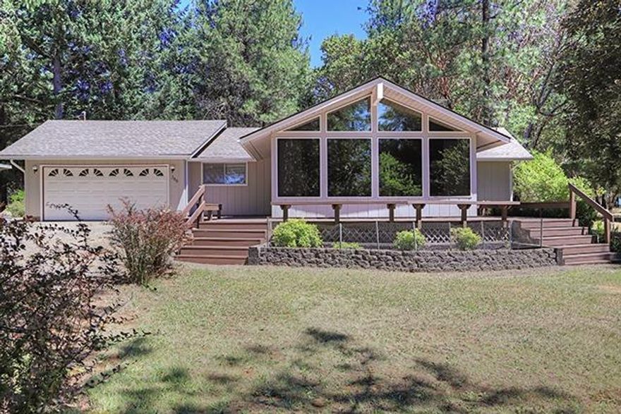 On a private country lane, and nestled amidst its own private forest of tall trees on 3.36 acres of level ground, sits this 1596 sq/ft charmer. Floor to ceiling windows allow natural light to fill the rooms and multiple glass sliding doors bring the outdoors inside...there's 1596 sq/ft in three bedrooms and two baths, with an inviting living area kept warm and cozy with a pellet stove insert. There are front and back decks that entice you to relax and enjoy the peace and complete quiet. Several outbuildings (including storage area that is 34x12) complete the picture, plus a fenced garden area and a 32x28 shop with a 12' door, concrete floor, it's own oil furnace and sub-panel. Come live the good life!