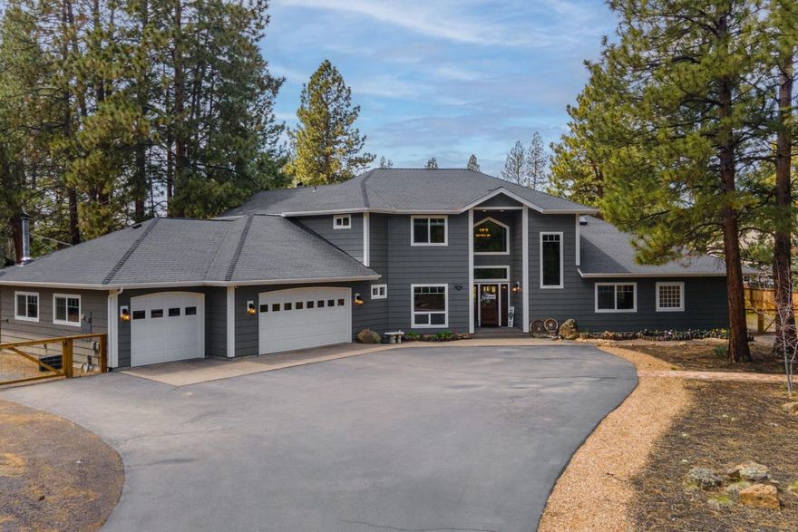 This beautifully updated SE Bend home offers privacy and serenity on 2.4 acres. Fully remodeled from top to bottom, it features 4 bedrooms and 4 full bathrooms, making it perfect for guests & family. The large vaulted great room has cozy vibes with a wood fireplace & floor-to-ceiling windows that let in tons of light. The kitchen boasts quartz counters and a large custom-built island. The main level has 2 bedrooms & 3 full bathrooms, including a large primary suite with a walk-in closet, steam shower, jetted tub & dual vanities. Upstairs, you'll find 2 additional bedrooms, a spacious loft, & a full bathroom. In addition to the home, there's a new 2,100 sq. ft. shop with a large office or mancave with a fireplace, a full bathroom, and a kitchenette. The house also has a large RV garage with extra storage. This property, just minutes from downtown Bend, has a landscaped backyard with a large grassy area, natural plants, a greenhouse, and abundant trees for added privacy and tranquility.