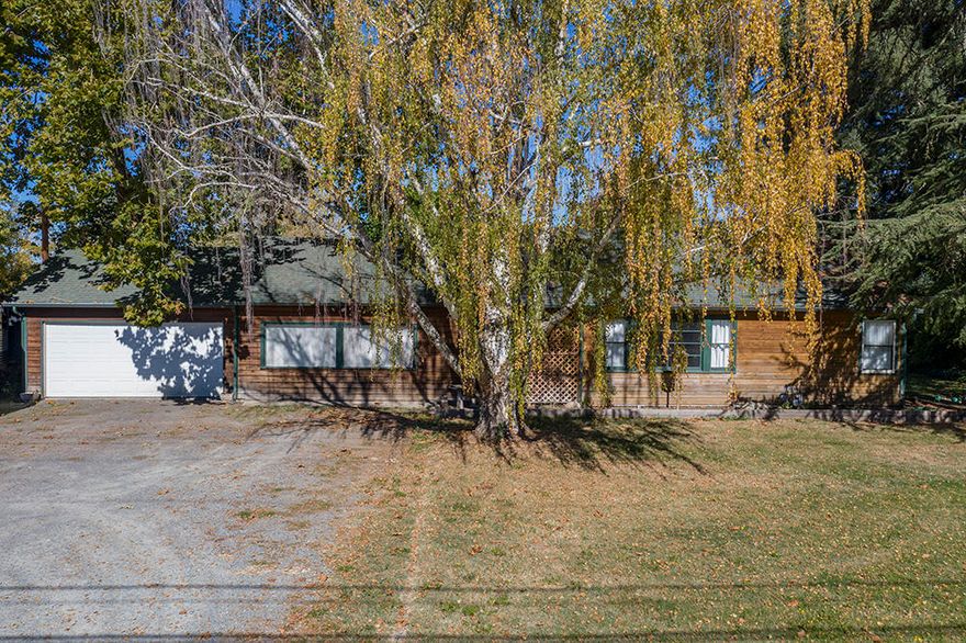 3 Bed 1 Bath Ranch-Style Home on 2.11 Level Irrigated Acres just minutes to Town! This Cedar-Sided Home is Attractive in Design, & offers Easy Rural Living. With a Country Kitchen, Large Living Room, & Den/Office, this Home is Exceptionally Welcoming & Comfortable. One Larger Bedroom, & Two Separate Guest Bedrooms, plus a Nicely Remodeled Bath. Comfortable WoodStove in the Den/Office, & a New Gas Wall Furnace in the Main Living Area. Some Original Pretty Hardwood Floors under portions of the Flooring could be revealed for added warmth. Attached Two Car Garage & plenty of Off-Street Parking Space. The Land here is Level & Useable, & the EFU Zoning provides for a variety of Uses. Well Pump was recently replaced, plus the property has Irrigation from GPID. Older but cool Barn is in poor condition, but nostalgic. Small Kiddos Playhouse, Established Fruit & Nut Trees, & TONS of Blackberries. This is a great little Mini-Farm, close to Town & within walking distance of the All-Sports Park.