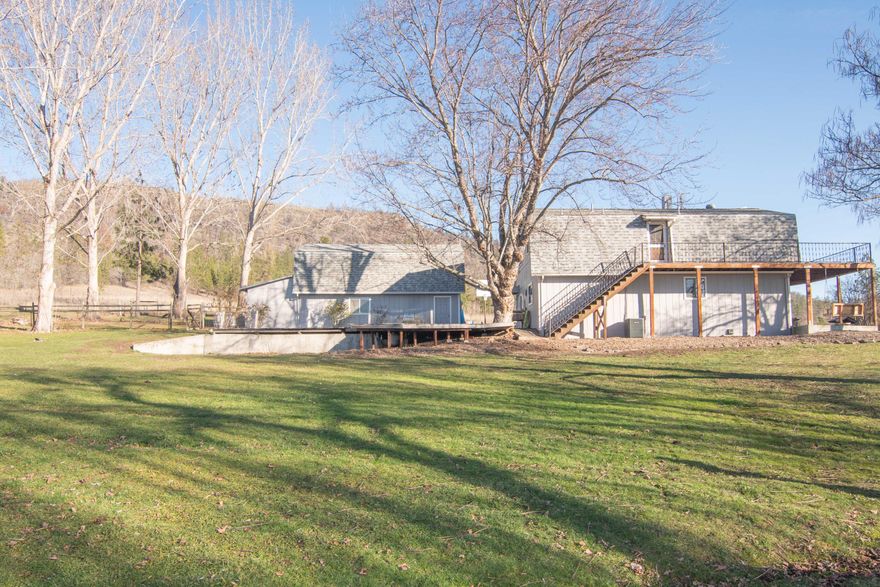 Views, barn, shop, extra room, and irrigated property with water rights! What more can you ask for in this quite picture-perfect property suited for horses in the lush green foothills of Eagle Point. When you pull up to this gated, fully fenced property at the end of the road, you will notice a well-maintained acreage with gorgeous views and plenty of room for all your animals. Step inside the spacious three-bedroom home with two huge bathrooms. Two of the upstairs bedrooms have beautiful T & G pine vaulted ceilings with access to an expansive wrap-around composite deck; all rooms are spacious with tons of storage. At the end of the garage is a separate covered area for the dogs with access to a fenced dog run. Property is fully fenced and cross fenced with a 3-stall barn. The greenhouses are nicely sized: 100' x 30'. There are endless possibilities: weddings, farm life, or just to enjoy the tranquil setting and views. Call for appt.