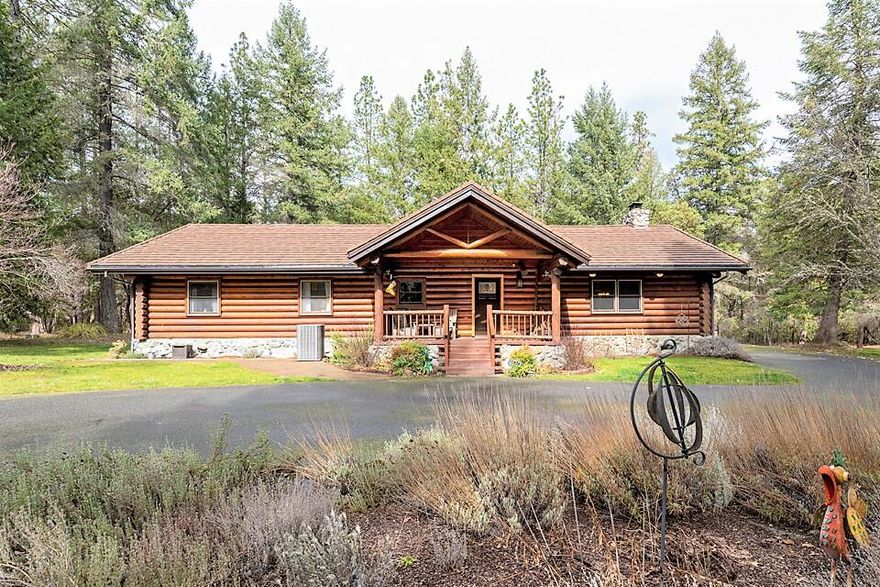 Serenity awaits. A winding tree studded driveway, Powell Creek Frontage & your own Log Cabin. Only 5 min to the Country store, 10 minutes to grocery store & 15 minutes to Grants Pass. This single level Montana log home was built w/dense high altitude logs that are approx. 10'' in diameter. The 2048sf home features a great room design w/that ''cabin'' feel & modern amenities. The main living area has vaulted ceilings w/log beams, a floor to ceiling REAL stone fireplace, engineered hardwood floors & wood cased windows. The adjacent kitchen is a chef's delight adorned w/leathered granite counters w/chiseled edges, center island cook station & eating bar. You'll love the large master suite! Master bath features granite counters, double vessel sinks, tile shower & built-in closets & storage. The home also has 2 nice bedrooms & indoor laundry. Outside is a huge garage shop building w/ hardship living space that is approx. 800sf with 1 bed & 1 bath. Contact L/A for info on High Speed Internet.