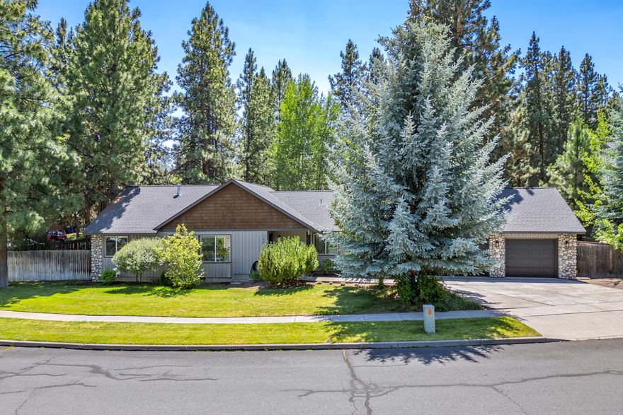 Discover charm and comfort in this single-level 3 bed, 2 bath home with a 3-car garage, situated on a corner lot in Quail Pine Estates. The great room welcomes with vaulted ceilings, radiant-heated tile floors, and a cozy travertine gas fireplace. Enjoy A/C in the hot summer days. The open kitchen has travertine tile counters and an inviting island/breakfast bar. The primary bedroom offers great separation of space & privacy from the other 2 bedrooms. Enjoy a double vanity, shower/tub combo, and a spacious walk-in closet. The 3-car garage provides ample parking and additional workspace or storage. Outside, the fully fenced backyard features mature trees, patio and a convenient storage shed. With potential for RV parking, no HOA fees, and proximity to Bend's Old Mill District, Deschutes River Trail, parks, and Pine Ridge Elementary, this home epitomizes convenient and comfortable living in Bend.