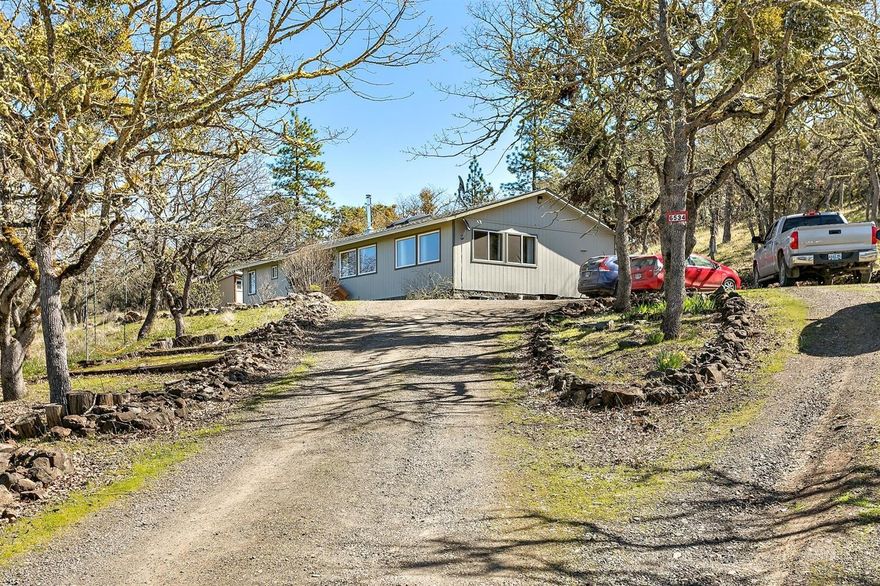 Fantastic views, acreage and privacy on this darling hobby farm with large shop in the woods above Agate lake. Home is single-level, stick built and includes vaulted ceilings, skylights, and open layout with windows to take in the views. Kitchen has been beautifully remodeled with hickory cabinets, new countertops with breakfast bar and island, tiled backsplash, and stainless appliances. Spacious master bedroom has vaulted ceiling, two closets, sliders to deck, and a beautifully updated bathroom with jetted tub and walk in shower. Two additional nice sized bedrooms, updated main bathroom, a convenient laundry room with lots of storage, and newer flooring throughout home. In addition to central heating and air, this home has a certified wood stove with tile surround. Good producing well with new storage tank. Much of property is irrigated through gravity fed system. Outside you will find a large fenced garden area, chicken coop, small barn with corrals, large shop attached to garage.