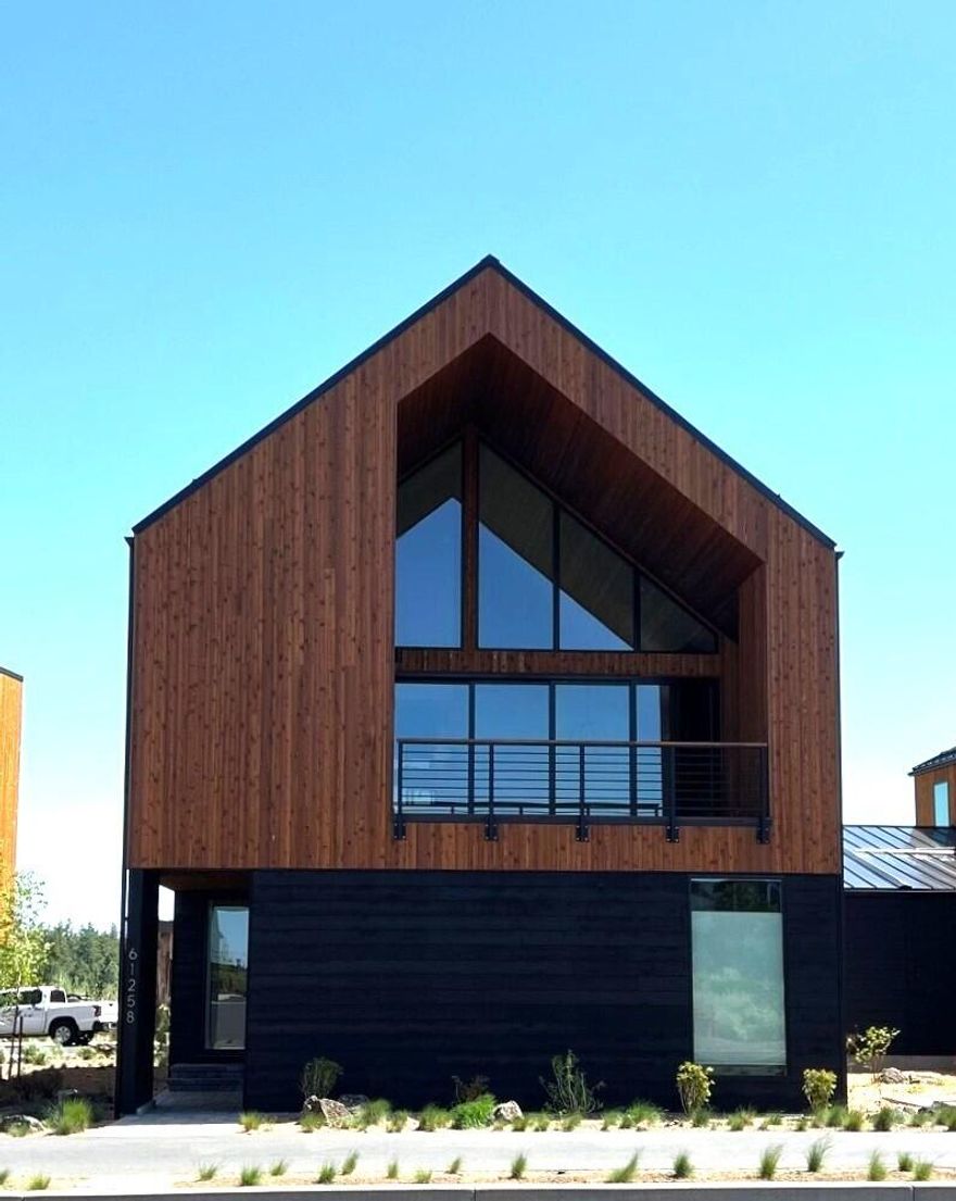 Come live the Chalet life in Tetherow! This townhome has a modern European design mixed with Bend's mountain style.  The reverse living design showcases beautiful mountain views and 2nd level privacy. The contemporary features and interior selections include engineered hardwood throughout main living area, beautiful Quartz countertops, a modern lighting package and a quadruple panel glass wall leading to the deck opening wide for incredible indoor/outdoor living space.  The floorplan includes a 3-car garage with epoxy floor, two bedroom suites + mudroom with washer/dryer on the first level.  Upstairs includes a grand great room with floor to ceiling windows, gas fireplace, kitchen with quartz island, powder bath and a large primary suite with it's own washer/dryer.  The ductless heating system provides energy efficient heating and cooling year-round. All of this in a location just steps from the Tetherow Owner's pool and trail system.