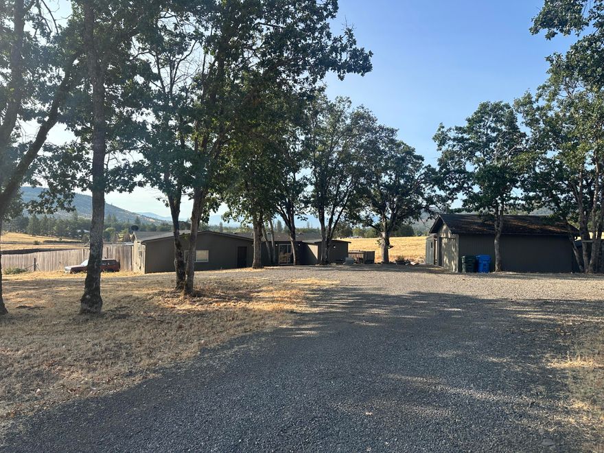Home on acreage located in Sams Valley with views of the Tablerocks. Initial investigation suggests that the second parcel may qualify for a home site. This 1440 sq ft home features 3 beds/2 baths. The property has plenty of parking for all of your toys, trailers, equipment, etc. There is a 1230 sq ft barn/shop  Convenient access with two entrances to the property. A recent well flow test shows an average production of approximately 10 gpm. Any potential purchaser should check with the county and conduct their own investigation into uses of the property.
