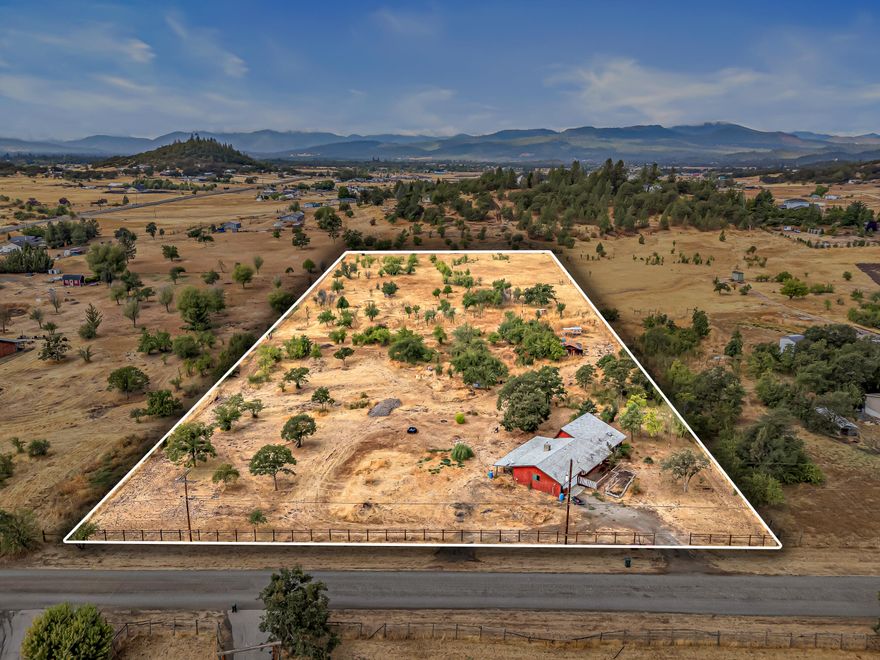 This is an excellent opportunity for investors or someone that is ready for a home project. The land here is a blank slate. Property is 5.02 flat acres that is fenced/cross fenced for plenty of room to roam in Eagle Point. A good well with a replaced pump in 2024ish and septic system that allows you to build your dream home or indulge in a fixer upper. Home is 1300 sq ft single story 3/2 home built in 1980. Included in the home, newer HVAC (5) years old and new garage door. Terms are cash or owner financing is possible with acceptable terms.