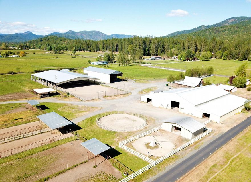 Nestled in the scenic Evans Valley, surrounded by the beautiful mountains of Southern Oregon, this practical working horse facility has been the home to Precision Training LLC for 14 years. The property draws irrigation water from Evans Creek.  This elaborate Breeding & Training Facility encompasses 32 stalls, an indoor arena, and outdoor/covered arena, sheltered turn-outs and pasture, lab & breeding area, double hot water wash rack, cattle handling & feeding facilities, 450 ton hay & shaving barn accented with white vinyl fencing.  The main barn houses a 1 bedroom apartment for help or a live in trainer. To complete the package, this estate includes a 4 Bedroom/2 Bath home, with a newly remodeled Kitchen!  A high bay shop with 2 commercial roll up doors is conveniently located near the house.