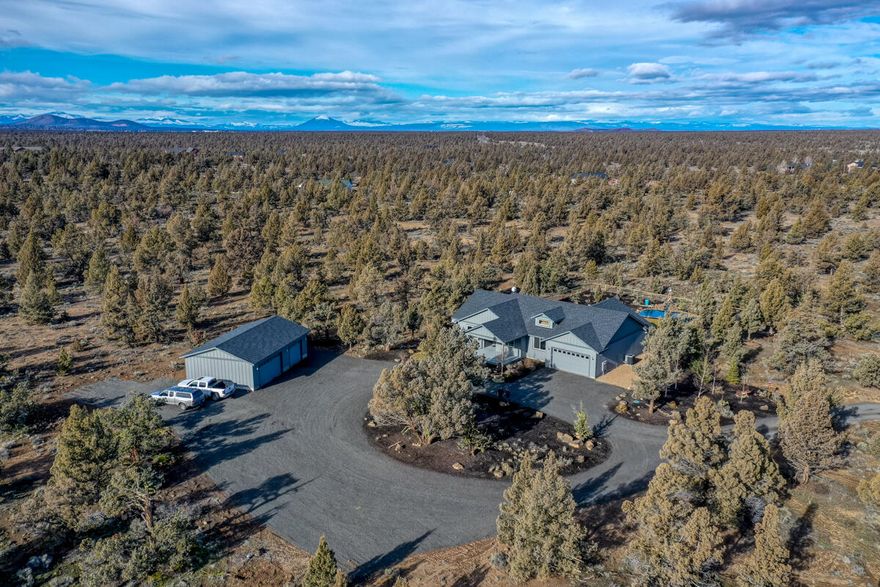 Complete privacy from this 2 year old builder's own home in West Powell Butte Estates. The subdivision is gated and the home sits on 21.89 fenced acres with a gated entrance to the property. Beautiful views of Smith Rock overlooking a pond and water feature. There is a 26 x 40 fully insulated 3 bay shop with 220 AMP service.  There is a 2 car garage attached to home. Full RV hookups with additional parking next to the home. The backyard is fenced with a pond and water feature. The home includes a complete fire suppression system delivered through the ceiling. The heat pump provides heating in the Winter and cooling in the Summer.  The gas fireplace in the family room is an additional heat source.  House has 3 expansive bedrooms and a den.  There is an additional bedroom and bath with a separate entrance off the back deck for guests.