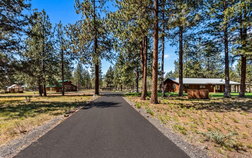 Behind a gate down a long, paved driveway sits a property that feels like a hidden retreat — surrounded by tall pines and beautifully maintained grounds — giving you space to breathe. The updated cabin-style home blends charm with function, featuring a new kitchen, remodeled bathrooms, tons of storage, and a large wraparound deck perfect for relaxing or entertaining. A detached studio adds flexibility, while the barn, greenhouse, private gym, and covered parking make the land as functional as it is peaceful. The property backs up to the Deschutes National Forest and is only one mile from Sisters.  Whether you're gardening, riding, or hosting, this is one of those rare Sisters properties that delivers it all — style, setting, and space.