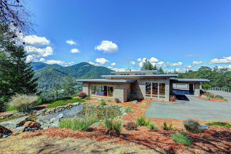 Nestled on a private ridge, not far from town, you will find this Frank Lloyd Wright inspired home, built w/ 180 degree views of the Rogue River. This timeless masterpiece was constructed in 2006 w/ 4793 sq.ft., including 3 bedrooms, 2.5 baths. As you enter this incredible home your eyes are drawn to the floor-to-ceiling walls of glass, which perfectly frames the breathtaking view of the river, valleys, and mountains. This custom architectural home is well appointed w/luxury amenities as well as unique & awe-inspiring features. Large rooms, 20' ceilings, hard flooring w/radiant heating, rich wood accents, all of which highlight & play in the bold design. You will be impressed w/ the over-sized great room, large dining room, upscale gourmet kitchen & private master suite w/views, fireplace and walk-in closet. This is one home you are not likely to forget. Lovely sun-room w/wet bar that looks onto a pond & waterfall for relaxing. Duralast roofing, finished double garage, gated entrance.