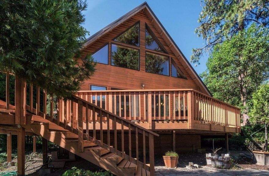 Gorgeous custom cedar home nestled in the privacy of over 11 acres with views and scenery. Notice the paved driveway as you enter and the several different kinds of deciduous, evergreen and pine trees. Beautiful wrap around deck where you can sit, relax and enjoy a morning cup of your favorite beverage and watch the sun slowly rise above the trees. Entering this home you will immediately notice the natural light flowing within, gorgeous windows and vaulted ceilings. The recently remodeled open kitchen has upgraded granite counters with chiseled edging, and under-mount composite granite double sink, and stainless appliances. There is plenty of counter space and storage. There are two rooms downstairs, one is currently being used as a family room but has built in storage with doors and can easily be converted back into a third bedroom. Upstairs you will find a wonderful master bedroom that has plenty of closet space. There is a wonderful sun deck where you can enjoy privacy and views of