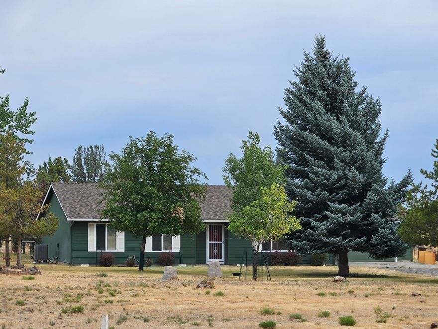 Discover peaceful country living on nearly 5 fully fenced acres with this well-maintained single-level home. Built in 1999 and offering 1,716 square feet of comfortable living space, this home features an open floor plan with hardwood and tile flooring throughout. The spacious kitchen includes newer appliances, and the home is equipped with an electric furnace, heat pump, and domestic water filtration system for year-round comfort and convenience. Enjoy the outdoor living on the large covered patio, ideal for relaxing or entertaining. Additional features include a private well (new in 2022), a newer roof(2022), and a 16 x 20 shop with concrete floor-perfect for hobbies or storage. A rare find with room to breathe just minutes from town.