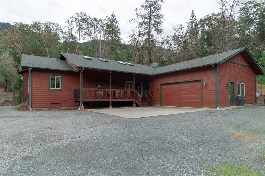 Woodsy hideaway with rolling landscape and creek. Owner built, 2006, 3 bed/2bath, custom home shows meticulous attention to quality and detail. Split floor plan - open concept, gourmet kitchen with gas stove, walk-in pantry, HVAC system for heating and cooling in addition to a wood stove and two fireplaces (one gas/one electric). Home is wired for surround sound. Front deck, back deck for outdoor cooking and entertaining, plus a deck with hot tub off the master suite, and oh my, what an amazing master suite: soaking tub with gas fireplace plus separate shower, double sinks, sit down vanity, walk-in closet! Home is light and bright with warm natural tones. Attached, two car, garage plus large detached garage with finished room above (room is 312 sq ft). Private feel, close to Grants Pass or Rogue River. Rural! Buyers - please be aware that this home is approxiately 1/3 of a mile down a gravel road. Borders BLM on one side. Move-in ready. See Virtual Tour.