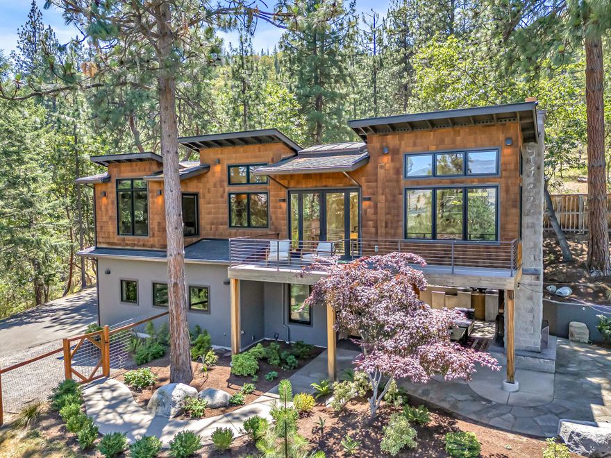 Perched high above Ashland, this custom-built masterpiece offers breathtaking views & unmatched craftsmanship. Thoughtfully designed with attention to detail, the home blends luxurious living with a unique ''treehouse'' ambiance- framed by windows that bring the outside in. The stunning kitchen features rift-sawn white oak cabinetry, an integrated Miele refrigerator, Wolf gas range, Bosch dishwasher & Basalt countertops. The primary bath is adorned with floor-to-ceiling glass tile & a spa-like shower. Downstairs, you'll find an office that doubles as guest quarters, with a built-in Murphy bed, & newly added 2nd full bath. The outdoor living space is the perfect spot to entertain, with gas heaters, a double-sided fireplace & outdoor kitchen. Relax in the in-ground spa as the sound of a cascading waterfall soothes your senses. This home is a rare blend of elevated design & natural beauty- perfectly situated on a private ½ acre lot close to downtown & bordered by 17+ acres of open space.