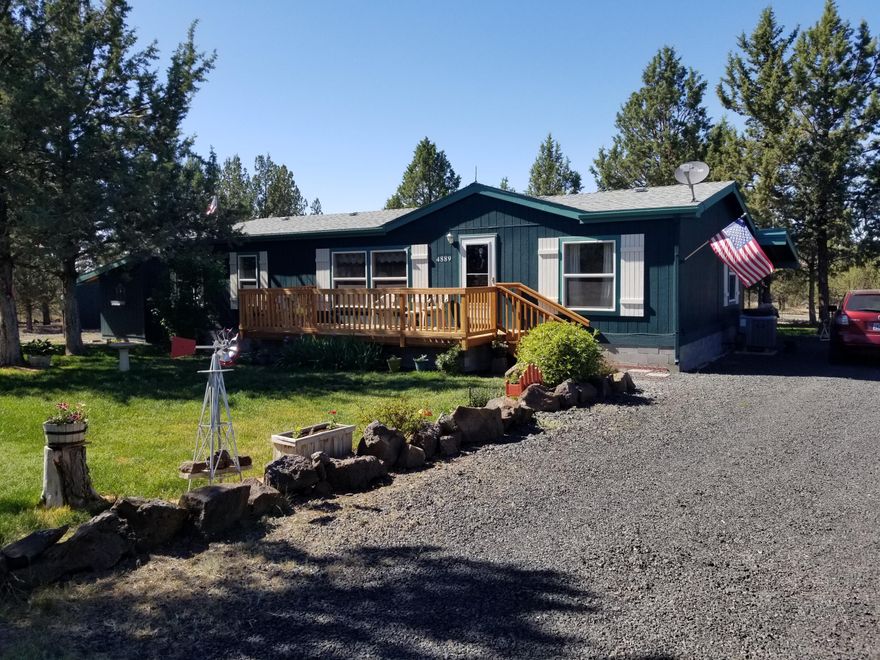 Spacious, very well maintained home on a fully fenced, nicely treed lot providing a secluded feeling, but close to the entrance to Prineville Lake Acres. Seller had a second well drilled in 2018, painted the exterior in 2016, Installed a new front deck in 2020, Installed a new heat pump in 2015, installed tile counters in the kitchen in 2016, installed new flooring in the kitchen, bath and utility room also in 2016, replaced all closet doors, and replaced the roof in 2018. The refrigerator is included and was purchased in 2015. Washer and dryer are included, purchased in 2016. Kitchen is open with plenty of storage. The front yard has a sprinkler system with controller. There is a tool shed, a 14'x14' ''She Shed'', a 24x24 detached double car garage with work benches and shelving. Power to all buildings. Property has an RV hookup with power and sewer. Home has a permitted stick built addition family room/den/office/mudroom with a sauna. There is a road association but not an HOA.
