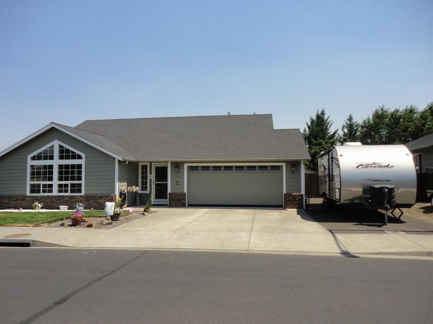 This 1475 sq ft home has 3 bedrooms and 2 baths built in 2004 it has been beautifully maintained. The spacious entry leads into the great room with vaulted ceilings and 2 large windows that bring in the natural light. Kitchen has lovely counters and newer track lighting. Beautiful oak hardwood floors in the dining and kitchen areas. The Master suite has a walk-in closet and large shower. The home has a two car garage and a paved RV pad, a shed for storage. There is a large in-ground pool with a salt water cleaning system. The pool is fenced and an alarm is on the kitchen door, as a safety protection The property is all fenced including the separate garden area