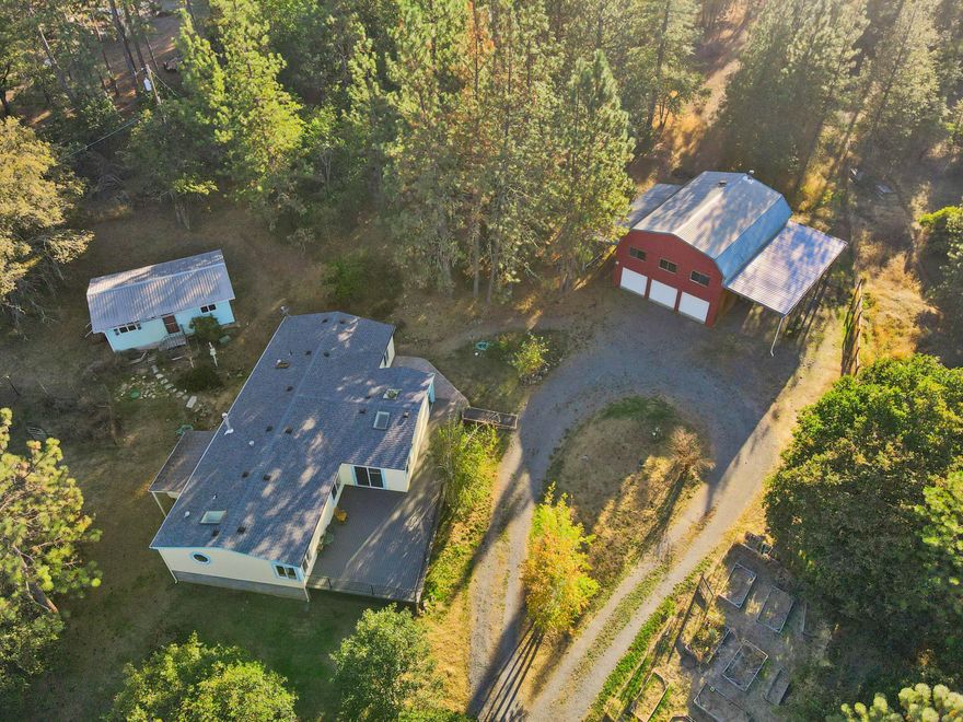 Discover the serenity of 5.26 acres tucked away in a private, peaceful setting with endless possibilities. This property features a spacious shop/garage with a workshop and an upper-level loft-like area, complete with AC and an elevator—perfect for hobbies, art, or creative pursuits. 

A large deck invites you to soak in the sweeping views, making it an ideal spot to relax or entertain.
The 1994 manufactured home offers 3 bedrooms, 2 baths, and a cozy new wood-burning fireplace—ready for someone to make it their own. Recent updates include a new septic system and water filtration system, ensuring peace of mind. An additional outbuilding offers excellent potential for ADU conversion, adding even more value and versatility.

With its blend of natural beauty, privacy, and opportunity, this property is a true gem waiting for the right vision.