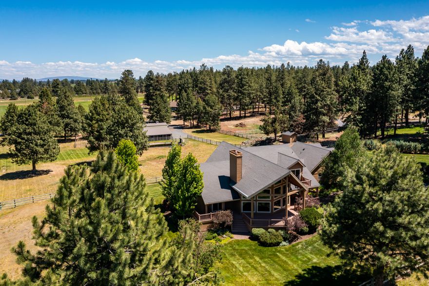 This spacious custom built estate home on over 4 acres on Bend's coveted Tekampe Rd has never before been offered for sale.  The first thing that will capture your attention as you pull into the drive is the park like setting with the wrap around two story porch with floor to ceiling windows accompanied by the soothing sounds of the front entry water feature that runs year round.   If you love entertaining, there are many options from the sun filled great room, kitchen with nook and dining area, and the bonus room with wet bar just off of the kitchen area leading to the covered back deck overlooking the pasture and 4 stall horse barn.  Two full primary suites, one on the main level, and one upstairs along with a guest suite over the garage provide the perfect separation for many different living situations.  The property includes 4.1 acres of irrigation, the barn includes a tack room, wash rack, automatic waterers, hay storage, and turn outs.
