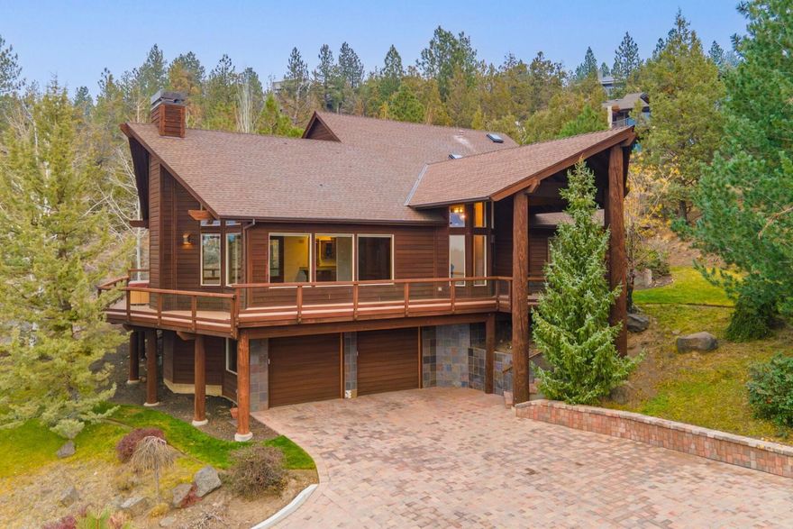 With one of the most breath taking views in all of Central Oregon, this Awbrey Butte home is a must see. The paver stone driveway is heated ensuring easy access in the winter, plus offers plenty of room to maneuver at the top. Take in the seven peaks of Cascade Mountain range from the wrap around deck. Entering the home, the tall vaulted ceilings create a grand living room, with mountain views framed in nearly every window. The Kitchen features Corian countertops, custom cabinets by local legend Keith Moon, custom range hood over the 6 burner gas cooktop & tons of storage. On the same level there are two spacious bedrooms, a full bath, powder bath & laundry room. Upstairs, the grand primary suite is extremely private. Take in the views from the private balcony plus enjoy a large en-suite with dual sinks, full tile shower & huge walk-in closet. Just off the garage on the lower level is a great flex space for an office or at home gym.