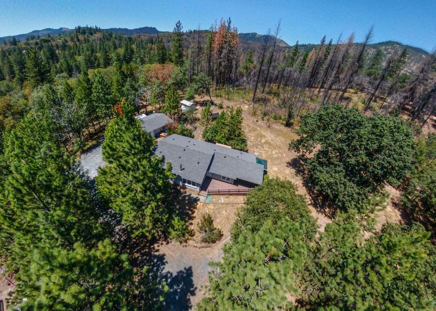 Come enjoy this nicely secluded home on nearly 5 acres. Home has 3 bedrooms, 2 baths, hardwood floors and a huge deck for outdoor living. Great room features vaulted ceiling, certified woodstove and lots of spacious living area. The kitchen boasts granite counters, spacious storage and lovely views across the property. Master is large and has a nice walk-in closet, big soaking tub and dbl. vanity. Outside is an oversized, detached 2 car garage with a carport alongside. There is also another detached building for RV storage or shop area. Property has easy access for large vehicles with a circle driveway. This nicely hidden acreage is located at the end of a road, has gated access and is minutes from I-5.