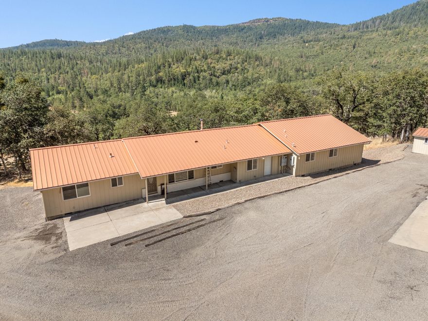 Retreat w/ views & multi-generational flexibility! 7.62 acres w/ views of Upper Table Rock & valley extending to Ashland. Security gate & backing to BLM land  w/  front-row access to wildlife & sunsets. Living room w/ wood-beamed ceiling, hardwood floors,  hearth ready for a wood stove. Kitchen w/ eat-in bar & flows into dining area. Designed for multi-generational living, the original wing w/ primary bedroom w/ hardwood floors & en suite bath, 2 more bedrooms & hall bath. Addition w/ 2nd fully accessible living suite w/ family room, 2nd primary suite w/ hardwood floors, roll-in shower, walk-in closet. Ideal for guests or independent living.  2 wings are connected via utility/multi-purpose room. Full-length deck. Oversized 3-car garage w/ windows, 220V electrical & workbench. Expanded, rocked parking areas for  multiple vehicles. New 1,500-gallon septic tank was installed in 2017.