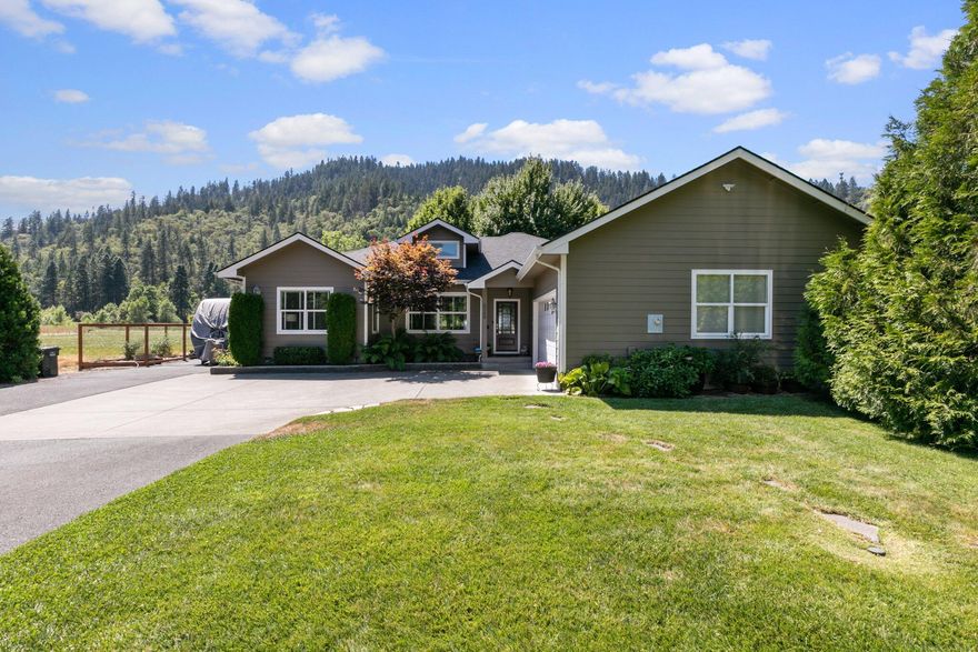 Your very own slice of paradise! There are just too many great features to be able to mention them all but some of your favorites will be the locally milled black walnut floors, leather finish granite on the bar, custom lights/fans throughout etc.  The best feature of this home though, is the location.  The property includes a section of stunning riverfront access and a surprisingly private back yard, fenced for dogs/children and a pasture area behind that. Best of all? This custom built home is tucked back off the highway so the road noise isn't a factor like a lot of river access properties in this area. Relax in the new hot tub and really take advantage of the majestic mountain views enjoying the varied wildlife that abounds along this stretch of the Rogue River Corridor. The additional detached one car garage has been built out as the perfect office or studio space. Open the garage door to enjoy the soft breeze flowing through at will. APPOINTMENT REQUIRED