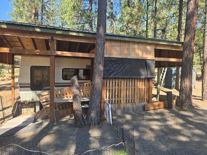 5.39 acre property with power, well and standard septic approval on file making it easy to build your dream home.

Alpine camper with a pole barn cover, conex storage container and water cistern  - perfect for weekend getaways or as a temporary living situation while you build.