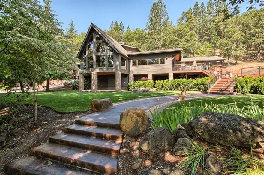 Exquisite home on the Rogue River you'll only tour once and immediately fall in love. This custom home is an absolute beauty with a rustic but classy style. The flooring is beautifully laid in a gorgeous Chestnut. A recent remodel accentuates the Chef's kitchen w/granite counter tops & custom distressed cherry wood cabinets. You'll love entertaining in this masterpiece just stepping out of the kitchen through a complete wall of Nano Doors onto a newly finished, 1000 sq ft deck, equipped with a vintage BBQ, lovely Catalina hot tub and glass fire-pit. If the amenities were't enough, soak in the stunning view of the Rogue River, just steps from the comforts of this fantastic home. For the garage, hobbyists will cheer the 30x50 polished cement floors, gas ceiling heat, high intensity fluorescent can lighting, built in steel cabinets & workbench. Did I mention the fishing? Drop a line along the 300 ft of river frontage.