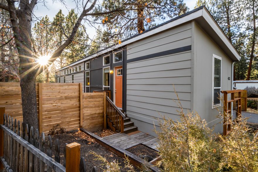 Step into this 2016 manufactured home featuring a bright, open floor plan with vaulted ceilings and plenty of natural light, views of trees from every window, abundance of kitchen & dining room cabinets and an oversize master bedroom. Sleek cordless blinds add a modern touch. The mobile home is being sold only - land is not included; though the seller has invested about over $26,000 in enhancements that elevate the overall setting. These include upgraded landscaping with raised beds & gardens areas, a back deck, irrigation system, lawn and bark installation, fully fenced yard, a quality storage shed with electrical, a heat pump, pavers, and additional exterior outlets near the hot tub area. Completely private and large, low-maintenance yard. This home feels bright, comfortable, and move-in ready.