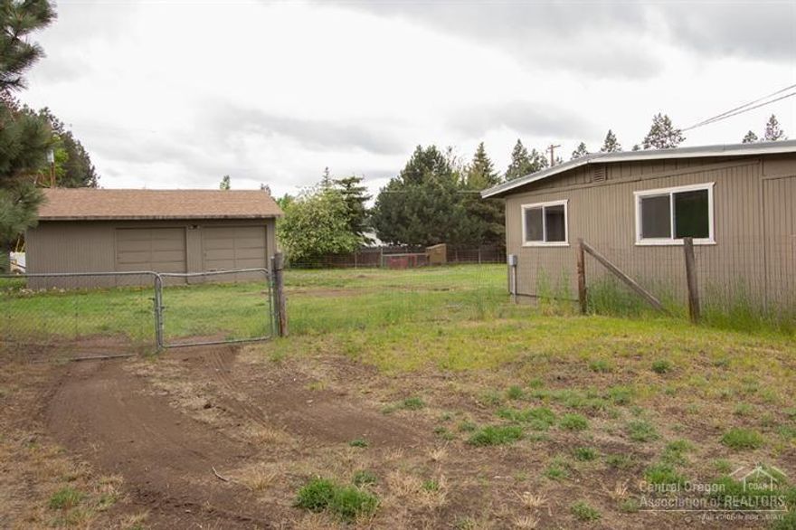 Potential development opportunity! Almost 1 acre in town with a good size shop! Home features natural gas fireplace for heat, vinyl windows and sliding glass doors, laminate flooring, deck, covered front porch, large utility room, and 2 office/storage rooms. Large detached shop/garage. Huge backyard and large side yard. Room for all of your toys and/or RV's. Buy now and hold for future development. Buyer to do all due diligence regarding potential development.