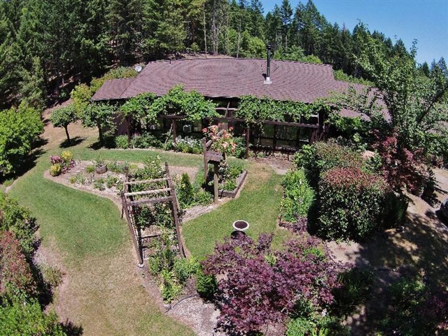 This is the most amazing botanical listing I've seen in my career. Beautiful, irrigated gardens with Iris and Peony nursery, roses, grapes, fruit trees and many perennials too numerous to list. Private and secluded 41+ acres on year round Mendenhall Creek. Custom built lovely home with vaulted tongue & groove ceilings, upstairs loft, ceramic tile flooring and friendly/happy feeling throughout. Fabulous location with detached finished 2-car over sized garage. Irrigation system with drip lines galore. Enjoy peace and quiet from one of the most unique finds in SW Oregon. Come see!!!!!!!!!