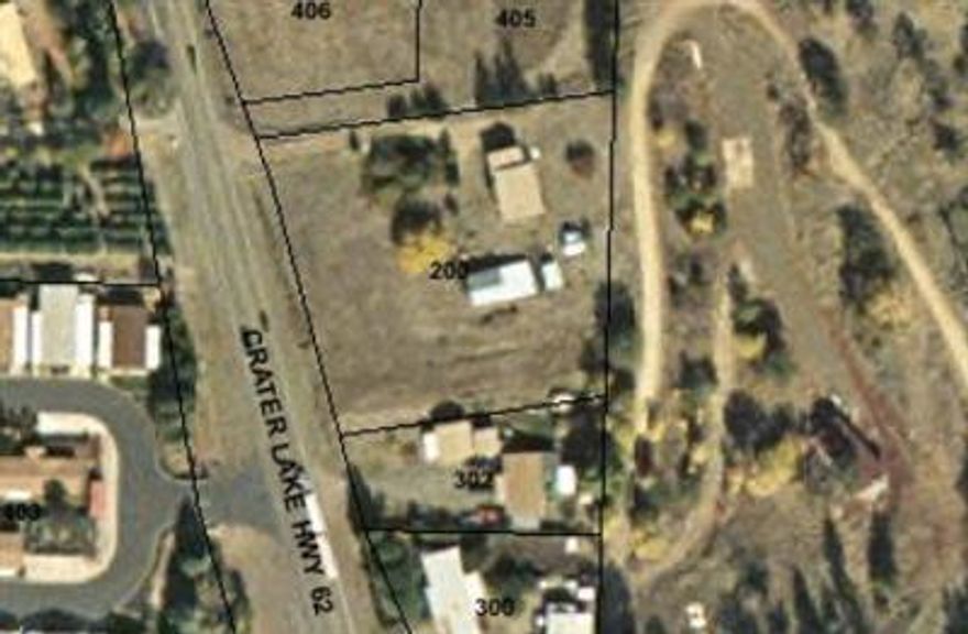 Dividable commercial highway frontage. City has list of approved uses. Old house and outbuildings - may not be useful. Good well and utilities to house.